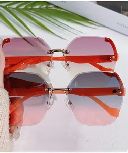 Detail of rimless sunglasses with gradient lenses and textured orange temples