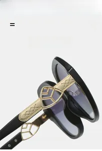 Macro detail of oval sunglasses showing gold metal hinge and purple gradient lenses