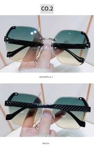 Detail view of rimless sunglasses featuring textured temples and green-yellow gradient lenses