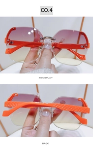 Detail view of orange textured temples and gradient purple rimless oversized sunglasses