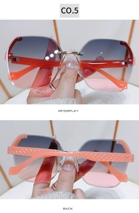 Detail view of rimless gradient sunglasses with textured orange arms and metal bridge