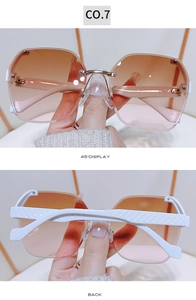 Detail of frameless sunglasses with orange gradient lenses and white quilted texture temples