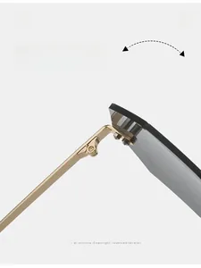 Detail of durable golden metal hinge on rimless spider web sunglasses with grey lenses