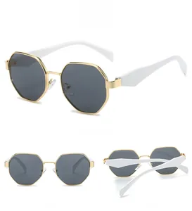 Vues détaillées de lunettes de soleil octogonales dorées avec verres gris et branches blanches