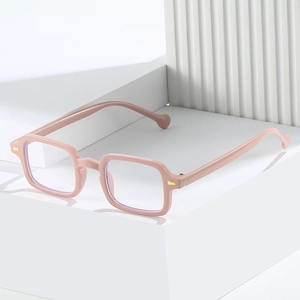 Monture de lunettes carrée rose pâle anti-lumière bleue avec rivets dorés sur socle