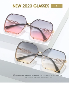 Close-up of frameless sunglasses with metal rivet accents and hollow chain temples