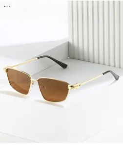 Detailed close-up of golden metal frame sunglasses with brown lenses and black temple tips