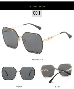 Close-up of rimless polygon sunglasses with gold chain temples and grey lenses