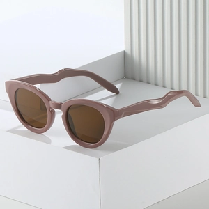 Oval avant-garde sunglasses in mauve pink with unique wavy temples and dark brown lenses