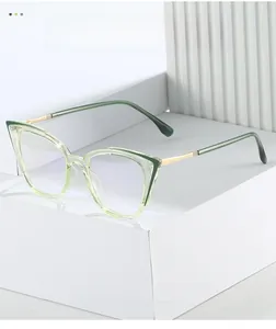 Detail of light green cat-eye glasses frame with golden metal temples on a white stand