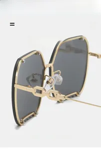 Detail view of octagon rimless sunglasses featuring gold metal chain-link temple arms