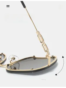 Close-up of durable golden metal chain hinge on rimless sunglasses with dark grey lenses