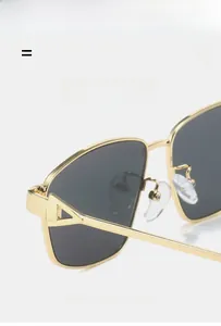 Detail of gold metal frame sunglasses featuring unique hollow triangle hinge craftsmanship