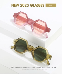 Close-up of hexagonal resin sunglasses in translucent pink and olive green tones