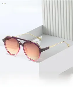 Close-up of pilot sunglasses featuring a gold metal double bridge and gradient lenses