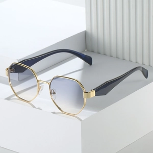 Lunettes de soleil octogonales en métal doré avec verres dégradés bleus sur socle