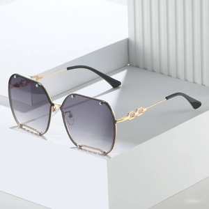 Frameless oversized sunglasses with gradient purple lenses and gold chain temples on white stand
