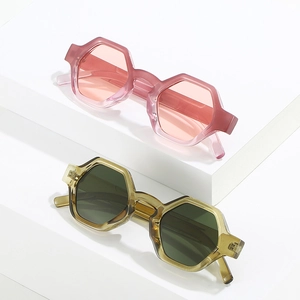 Modern hexagonal chunky sunglasses in pink and green on minimalist white pedestals