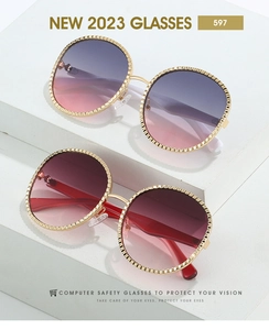 Détail de lunettes de soleil ovales avec monture ondulée dorée et verres dégradés