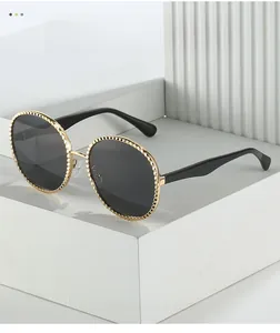 Vue détaillée de lunettes de soleil ovales dorées avec monture métallique texturée