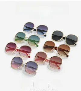 Détails de lunettes de soleil ovales avec monture en métal doré et verres multicolores