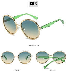 Vue détaillée des lunettes de soleil ovales avec monture ondulée dorée et verres dégradés
