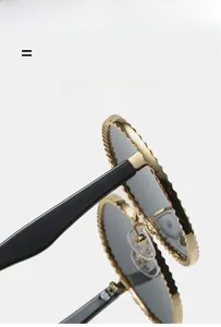Détail de lunettes de soleil ovales avec monture en métal doré et bords texturés