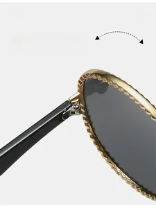 Détail de la charnière en métal robuste sur lunettes de soleil ovales à monture dorée