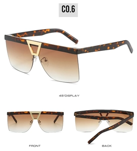 Detail view of tortoiseshell oversized sunglasses with brown gradient lenses and gold nose bridge