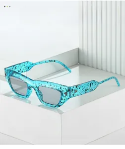 Dettaglio occhiali cat eye con motivo a inchiostro verde acqua e rivetti metallici
