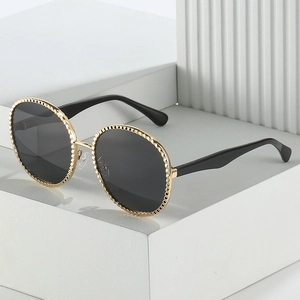 Lunettes de soleil rondes vintage avec monture en métal doré texturé et verres noirs