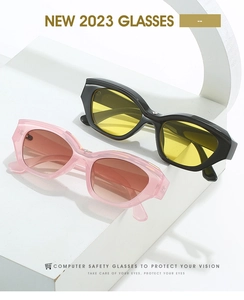 Detail of retro cat-eye sunglasses with yellow and pink lenses on white geometric blocks