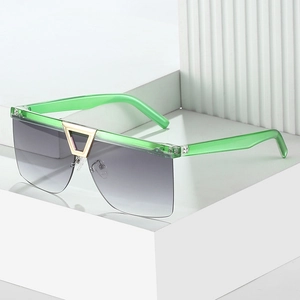 Fashionable oversized square sunglasses with green frames and signature gold triangle detail