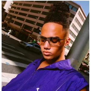 Close-up of translucent brown pilot sunglasses worn with a purple zip-up puffer vest