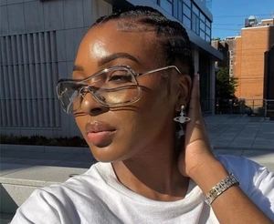 Close-up of Y2K sunglasses with Saturn orbit earrings and silver H-link bracelet