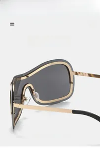 Detail of Y2K sunglasses with gold metal frame, seamless grey lens and sleek nose bridge
