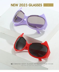 Detail of Y2K devil horn sunglasses with purple and red frames on white geometric stands