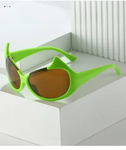 Detail of neon green cat-eye sunglasses with sharp horn design and dark brown lenses