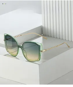 Detailaufnahme der Katzenaugen-Sonnenbrille mit grünem Rahmen und goldenen Bügeln
