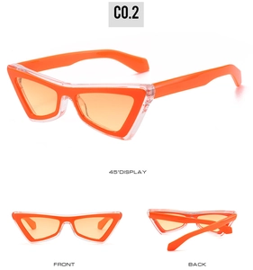 Detail view of triangular cat-eye sunglasses with orange inner frame and tinted lenses
