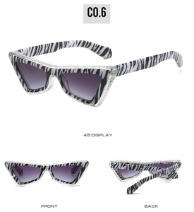 Detail view of cat-eye sunglasses with zebra stripes and purple gradient lenses