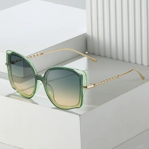 Cat-Eye-Sonnenbrille mit grünem transparentem Rahmen und goldenen Metalbügeln