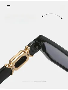 Macro detail of reinforced golden metal hinge on black polygon sunglasses with durable texture