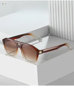 Detail of gradient brown sunglasses with gold hexagon metal trim on white background