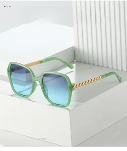 Detailed shot of gold hollow-out metal temples and light green square sunglasses frame