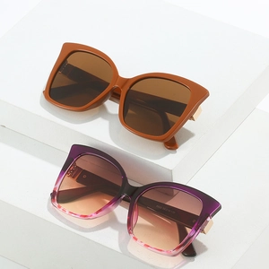 Cat eye butterfly oversized sunglasses with marble pattern and gradient lenses on white pedestal