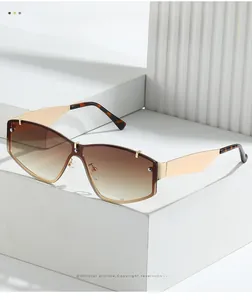Détail de lunettes de soleil sans monture oversize avec verres dégradés et branches dorées