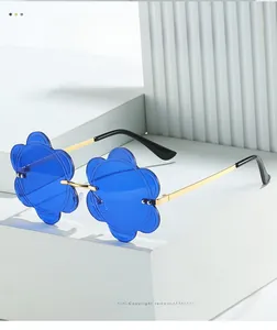 Detail of rimless sunflower sunglasses with vibrant blue petal lenses and gold metal arms