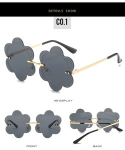Macro detail of rimless flower-shaped gray sunglasses with golden metal temples