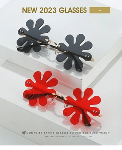 Detail view of flower-shaped rimless sunglasses in red and black colors with metal bridge